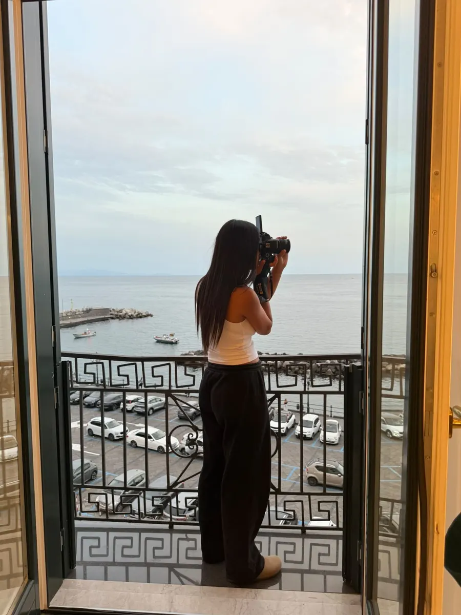 Lihi Matzri photographing the sea view from a balcony