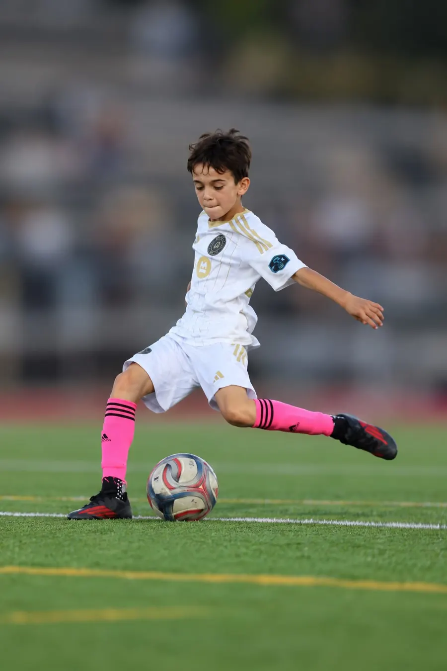 Young player striking a soccer ball mid-game